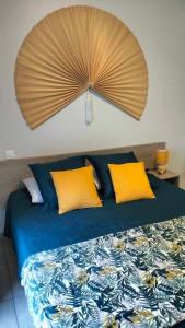a bedroom with a bed with yellow and blue pillows at Tikazéla - Escale Tournon-Sur-Rhône in Tournon-sur-Rhône