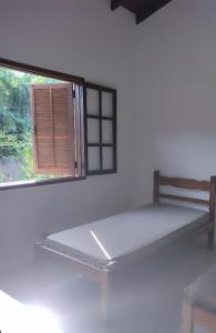 a bed in a room with a window at Casa praias de São Gonçalo em Paraty RJ in Paraty