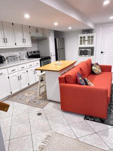 a kitchen with a red couch in the middle of a kitchen at Central to Ottawa & Gatineau Park, Spacious & Comfortable 2-Bedroom Retreat with Free Parking in Gatineau