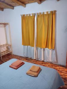 2 Handtücher auf einem Bett in einem Zimmer mit Fenster in der Unterkunft Cabañas lunita 2 in San Rafael