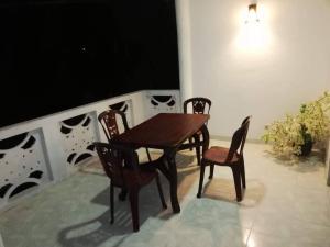 a wooden table and four chairs on a balcony at The Travel Inn in Ahangama