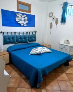 ein Schlafzimmer mit einem blauen Bett und einer blauen Decke in der Unterkunft Casa Tequi a 200mt dal mare in Terrasini
