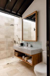 a bathroom with a sink and a shower at Wave House - Surf Camp in Canggu