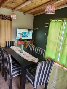 ein Esszimmer mit einem schwarzen Tisch und Stühlen in der Unterkunft Cabañas lunita 2 in San Rafael
