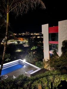 una piscina frente a un edificio por la noche en Pitaya Suítes, en Cunha