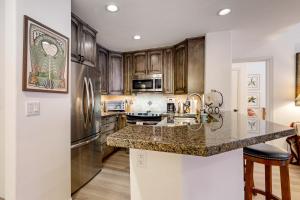 a kitchen with wooden cabinets and a granite counter top at Seasons Lodge #202 in Edwards
