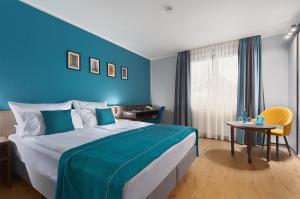 Trip Inn Hotel Krefeld في كريفيلد: غرفة نوم بسرير كبير بجدار ازرق