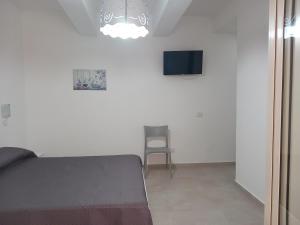 - une chambre avec un lit, une chaise et un lustre dans l'établissement Appartamento La Dama, à Scilla
