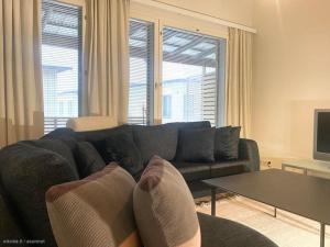uma sala de estar com um sofá e uma mesa em Saunallinen kaksio 53 m2 meren läheisyydessä em Kokkola
