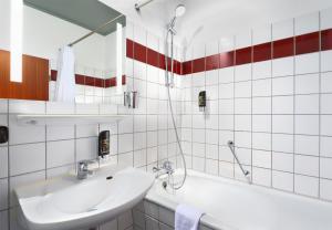 y baño blanco con lavabo y bañera. en Trip Inn Hotel Krefeld en Krefeld