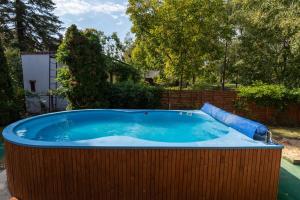 a large hot tub in a wooden fence with a inflatable at Tiszapart-Vendégház in Tiszakécske