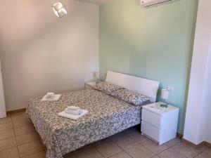 a bedroom with a bed with two towels on it at La Collina: L’alba in Castiadas