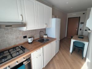a kitchen with white cabinets and a sink at Skeggi Space in Bari