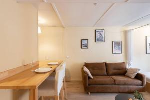 un soggiorno con tavolo e divano di Cabana & Le Petit Marronnier / Place Bellecour 2 a Lione