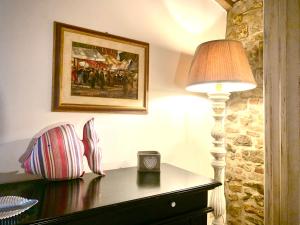 eine Lampe auf einer Kommode neben einer Wand in der Unterkunft Casa Malù Suvereto Antica Dimora with two bedrooms in Suvereto
