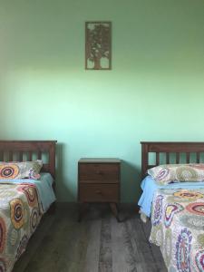 a bedroom with two beds and a nightstand between them at Casa de campo “Doña Elisa” in San Andrés de Giles