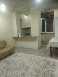 a living room with a couch and a kitchen at apart NUR in Bishkek