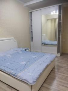 1 dormitorio con cama y espejo grande en apart NUR en Bishkek