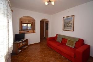a living room with a red couch and a tv at Casa Dolores in Padola