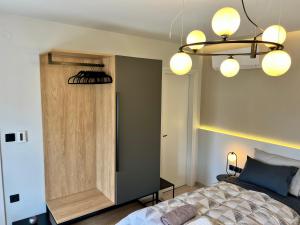 1 dormitorio con cama y lámpara de araña en Suite Rooms - Fine Living, en Vévi