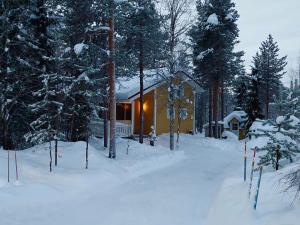 ein Haus im Schnee mit schneebedeckten Bäumen in der Unterkunft Lapland Forest Lodge in Rovaniemi