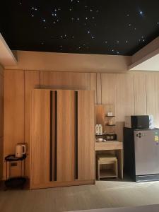 een keuken met een koelkast en een tafel met een magnetron bij Rema residence China town in Bangkok