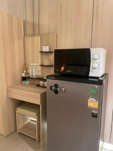 a small refrigerator with a microwave on top of it at Rema residence China town Main Road in Bangkok +7 photos