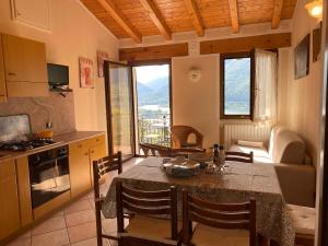 a kitchen and a dining room with a table and chairs at Casa Carla, bis 4 Personen, Garten, Balkon mit Blick auf den See und die Berge in Crone