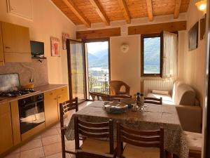 Una cocina y un comedor con mesa y sillas. en Casa Carla, bis 4 Personen, Garten, Balkon mit Blick auf den See und die Berge, en Crone