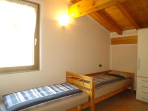 a bedroom with two beds and a window at Casa Carla, bis 4 Personen, Garten, Balkon mit Blick auf den See und die Berge in Crone