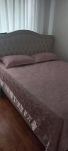 Una cama con almohadas rosas encima. en Holiday Home Peaceful Retreat, en Visoko