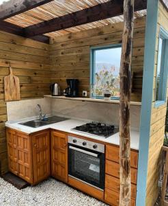 eine Küche mit einem Herd und einem Waschbecken in einer Hütte in der Unterkunft Yurt in La Nucia met zwembad in La Nucía