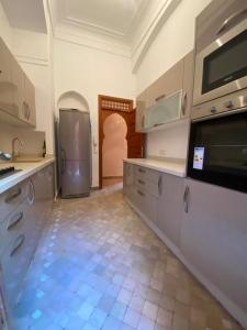 a large kitchen with a refrigerator and a tile floor at Villa les oliviers in Marrakesh