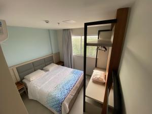- une petite chambre avec un lit et un miroir dans l'établissement Apartamento Aqualand, à Salinópolis