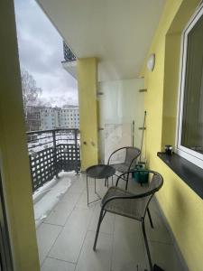 balcón con 3 sillas, mesa y ventana en Apartment Swinemünde, en Świnoujście