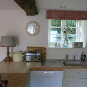 a kitchen with a sink and a toaster on a counter at Characterful Cotswold cottage in Cirencester