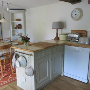 a kitchen with gray cabinets and a counter top at Characterful Cotswold cottage in Cirencester
