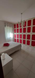 Cette chambre comprend un lit avec des portes rouges et rouges. dans l'établissement LA VIA DEL MARE, à Iglesias