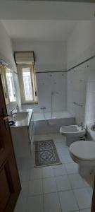 La salle de bains est pourvue de 2 lavabos, d'une baignoire et de toilettes. dans l'établissement LA VIA DEL MARE, à Iglesias
