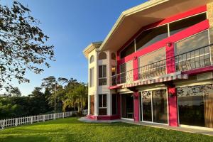 un edificio rojo y blanco con patio en Arenal Lake House, en Nuevo Arenal