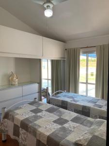 1 dormitorio con 2 camas y manta a cuadros en Cabaña El Hornero en Mina Clavero