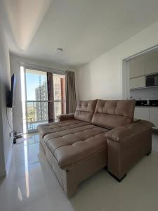 a living room with a brown couch and a television at Moderno e novo apt em frente o shopping Boulevard in Vila Velha