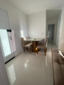 a white living room with a table and chairs at Moderno e novo apt em frente o shopping Boulevard in Vila Velha