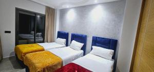 um quarto com duas camas com cabeceiras azuis em Apartment Tangier City Cornice em Tânger