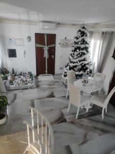 salon z choinką świąteczną i białymi krzesłami w obiekcie Casa scopelliti w mieście Calasetta