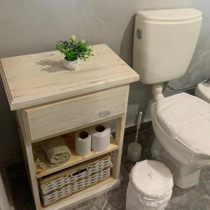 a bathroom with a toilet and a table with a plant at Departamento Temporario amueblado in Corrientes
