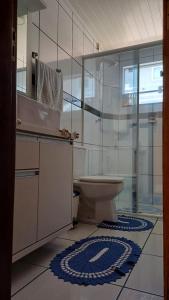 a bathroom with a toilet and a sink and a mirror at Residencial da Leta in Garopaba +20 photos