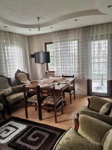 a living room with a dining room table and chairs at 1915 Çanakkale Köprü manzarali 700m2 bahceli mustakil ev in Canakkale