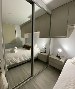 a bedroom with two beds and a mirror at Tu Hogar de Lujo en el Corazón de Resistencia in Resistencia