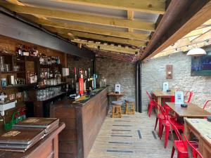 un restaurante con un bar con mesas y sillas rojas en The Old Bath Arms, en Frome